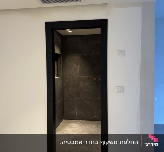 פתח דלת עם מסגרת שחורה וקירות אפורים